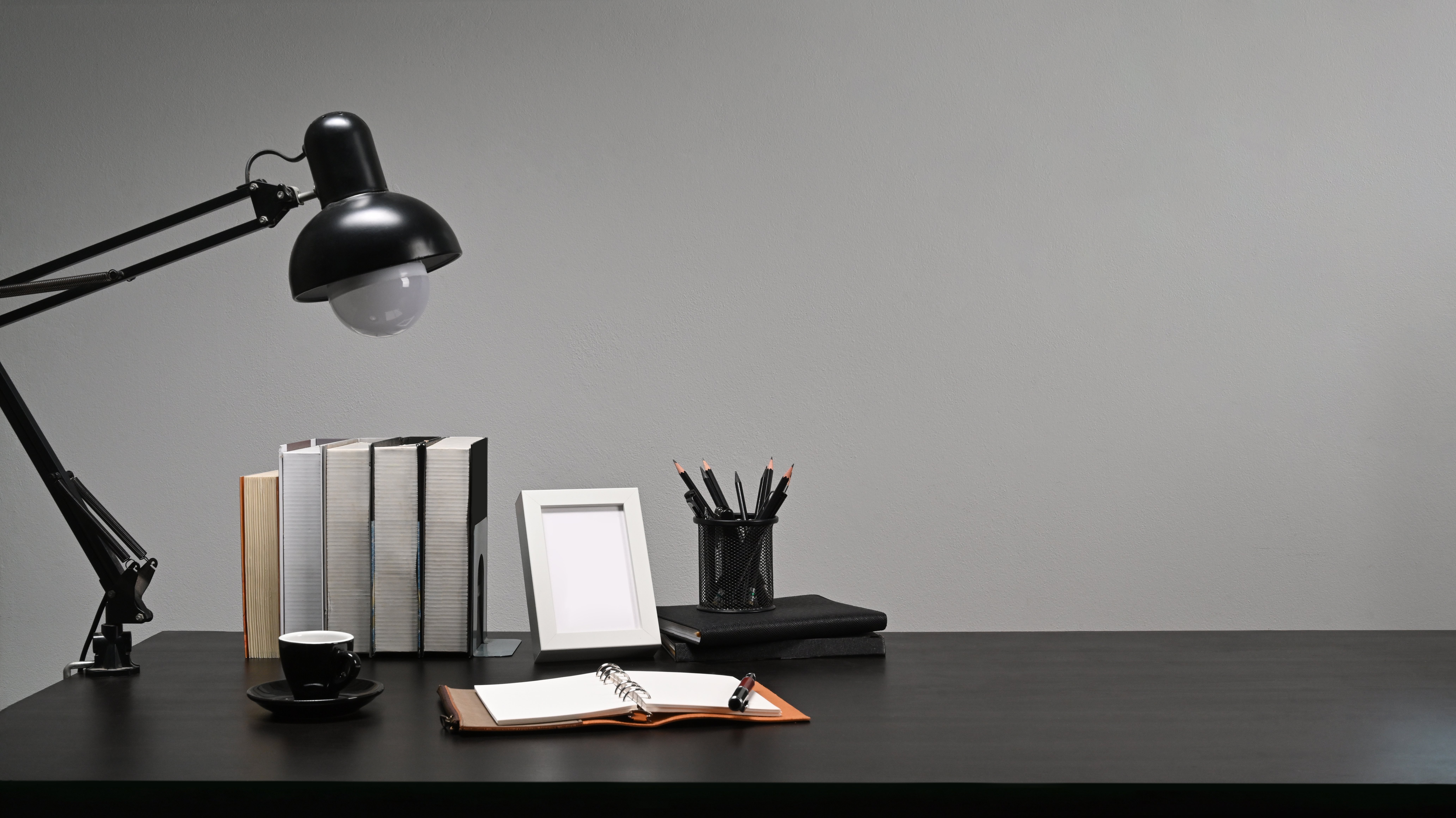 Minimal styled desk with lamp, books and organizer
