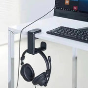 HANG clamped to a white desk holding headphones